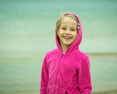 在这个小红帽反对冰冷的海洋小女孩微笑着的肖像