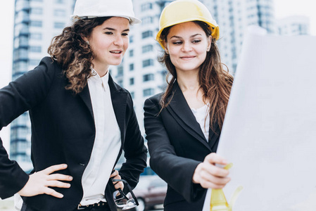 两个年轻漂亮的商业妇女工业工程师在施工