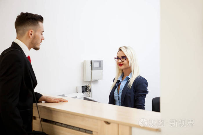 办公接待区的生意人与秘书谈话
