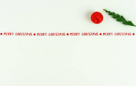 圣诞作文从一个圣诞节的树枝上的一个红色的圣诞树球和新年丝带的白色背景。复制空间