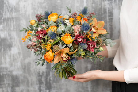 美丽的婚礼花束在女人手里混合着鲜花。花店花匠的工作