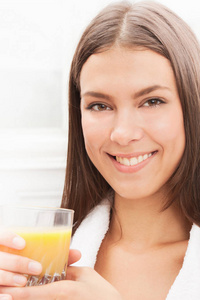 微笑年轻迷人的白种女人喝橙汁