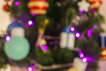 季节问候的概念圣诞树的模糊和重新调整的豪华装饰和闪光的紫色灯泡