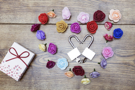 情人节的象征。礼品盒和两个心形锁, 玫瑰在木桌上。顶部视图