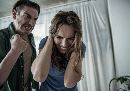 可怕的女人从好斗的男人那里得到威胁照片