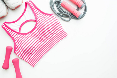 运动胸罩, 运动鞋, 体育和健身设备在粉红色颜色口气在白色背景与拷贝空间