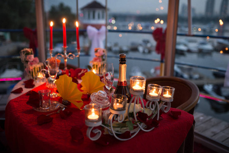 烛光晚餐桌上有鲜花,眼镜和盘子照片