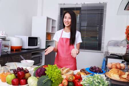 年轻漂亮的女人在厨房里做饭