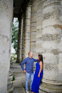 可爱的情侣在对老城堡的爱。穿蓝色连衣裙的女孩