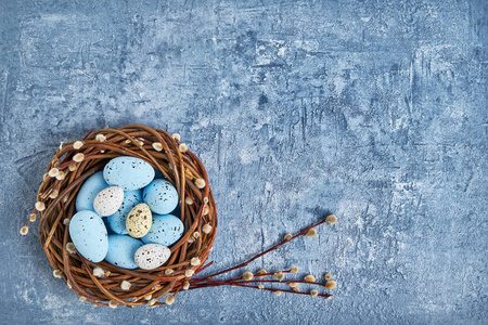 复活节花圈和五颜六色的复活节彩蛋在蓝色背景。顶部视图, 复制空间