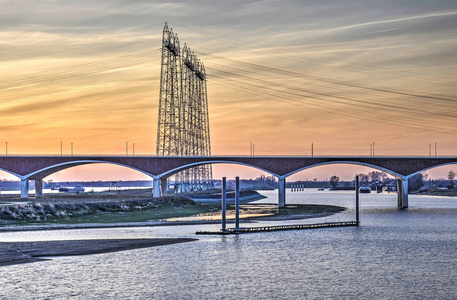 城市桥梁 De Oversteek 横穿 和 electicity 线横跨在奈梅亨附近的新被创造的海峡的夜看法, 荷兰