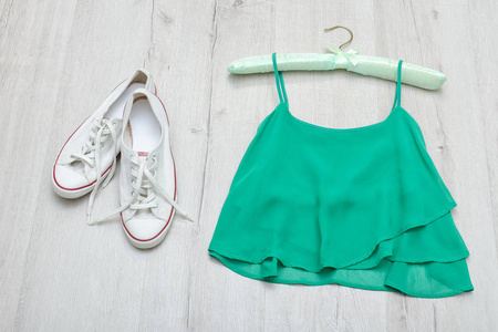 绿色的顶部, 白色运动鞋和薄荷袋。时尚理念