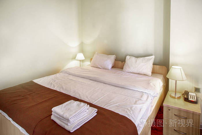 静物画的一张带有软垫的酒店卧室里的空床照片-正版商用图片0ug5zo