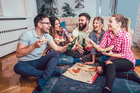 一群年轻的朋友吃披萨在家里聚会照片