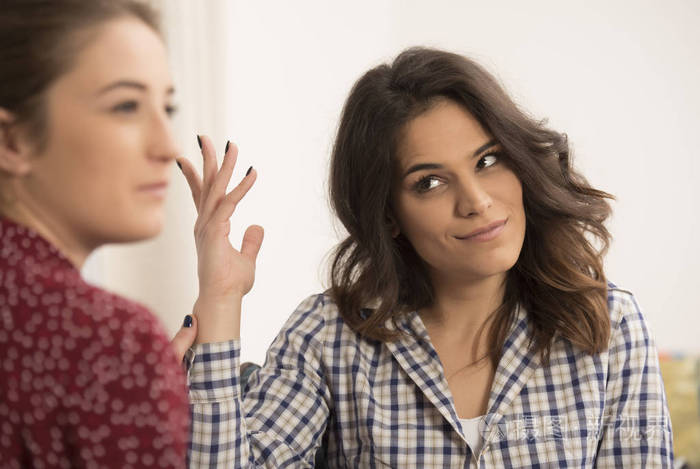 两位女性朋友坐在客厅的沙发上聊天