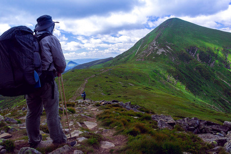 微笑与背包徒步旅行者遥望远方在山区春,秋两季,少女独自出山,眺望