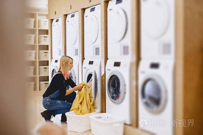 一个女人把床单装在洗衣房里洗乾净.