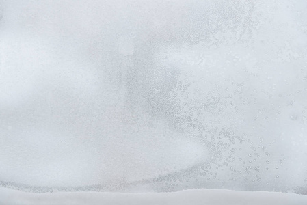 窗户上有霜冻的图案。玻璃上的冰和雪的质地。抽象冬天背景