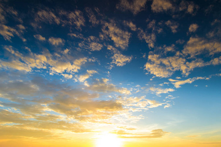 蓝色和橙色的夕阳的天空与太阳的光线。自然景观为背景的