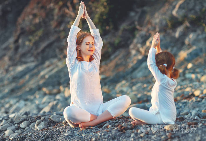 快乐家庭的母亲和孩子做瑜伽,冥想在莲花岗位