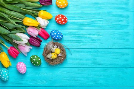 复活节彩蛋与五颜六色的郁金香在木质背景, 复活节假期概念。复活节装饰