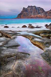 美丽的日落挪威海岸冰冷的北极海滩上风景如画的石头景观