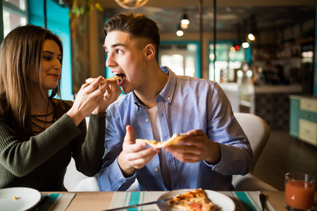 夫妇一起分享比萨饼和一起吃在咖啡馆愉快。比萨时间
