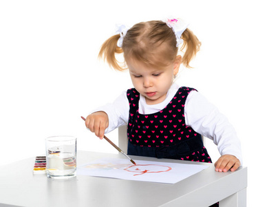 一个小女孩正在桌子上画画。