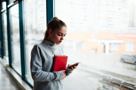 年轻妇女与文学书读 sms 消息在数字式电话