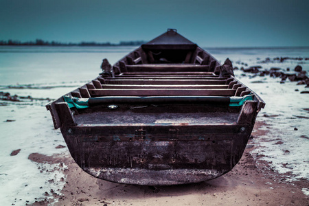 一艘老船在冬天的早晨被扔上岸