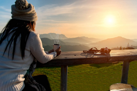 在阳光下坐在户外阳光光享受她的早晨咖啡,复古,软和选择焦点在喝咖啡