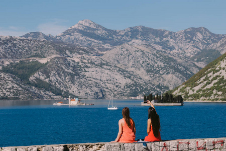 在黑山的两个女孩在海边和山上旅游。Perast