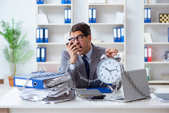 忙碌的雇员被锁在办公桌前