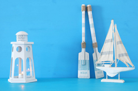航海概念与白色装饰灯塔灯笼, 木桨和小船在蓝色背景下