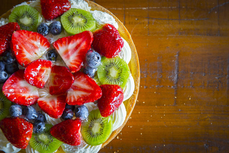 蛋糕与奶油, 草莓, 蓝莓和猕猴桃在老木桌, 与拷贝空间