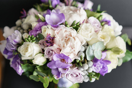 新娘结婚花束与牡丹, 小苍兰和其他花在黑色扶手椅上。淡紫色的春天的颜色。早晨在房间里
