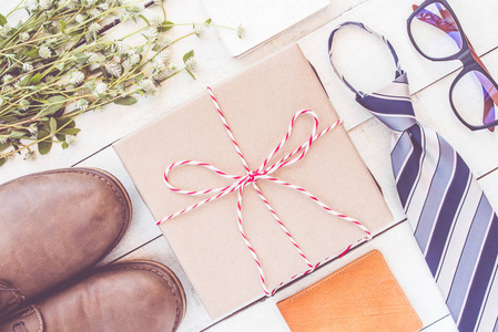 父亲节的概念与礼品盒, 领带, 鞋笔记本和花白色木板板。顶部视图