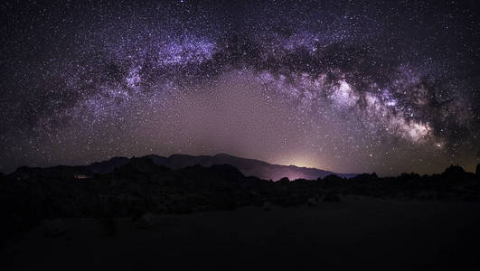 景观在夜空中用星星和银河星系观看沙漠。图像描绘了天文摄影和自然。在光污染较少的地区徒步旅行者可以看到宇宙