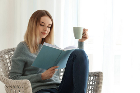 在家看书的年轻妇女喝茶在家里的沙发上读书的年轻女人晚睡在床上的
