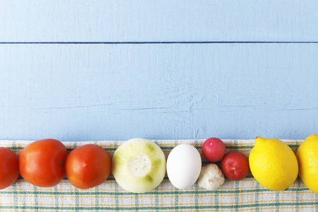 生鸡蛋, 西红柿, 洋葱, 大蒜和柠檬在木质的背景。健康早餐的生料原料。顶部视图