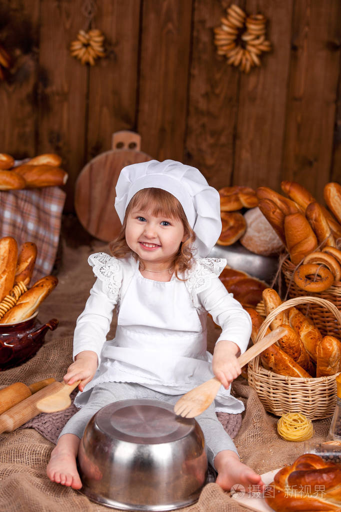 愉快的厨师婴孩笑扮演厨师, 面包店许多面包