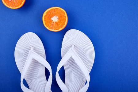 夏天的概念。白色的触发器, 橙色的水果, 贝壳在蓝色的纸张背景。平躺。复制空间