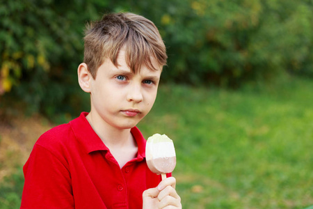 严肃的男孩与冰淇淋。童年情感与美的状态