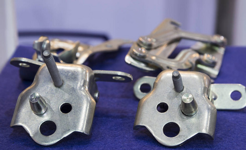 一个人给汽车引擎盖上的铰链上油汽车车门铰链, 新零件