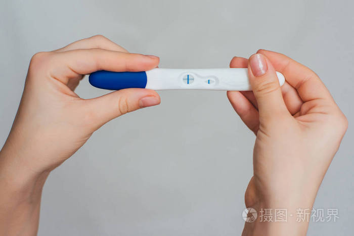 怀孕测试在女孩的手以一个正面结果