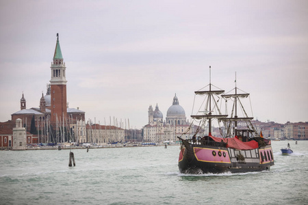 在意大利威尼斯的背景下, 与圣乔治教堂和圣玛丽亚德拉致敬教堂在水道上航行的船