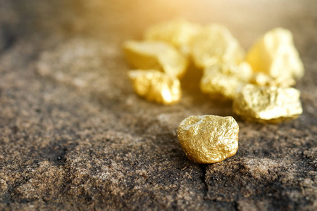 纯金背景在石地板上的矿井中发现的纯金矿石照片