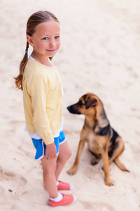 可爱的小女孩，用她的狗在海滩在暑假期间