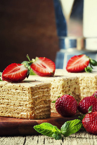 自制蜂蜜蛋糕装饰草莓和薄荷, 老式木材背景, 选择性重点