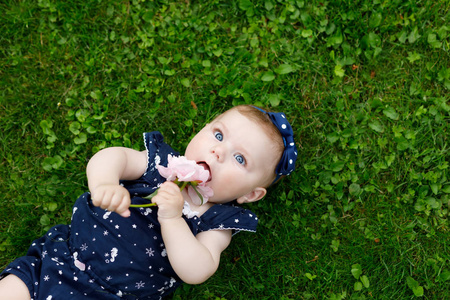 可爱的宝宝女孩与草莓六飞蛾的草地上